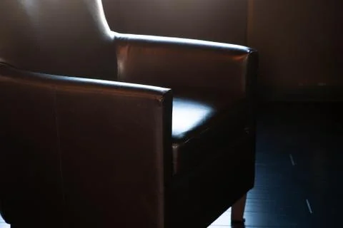 Dramatic dark lighting on comfortable office chair Stock-Fotos