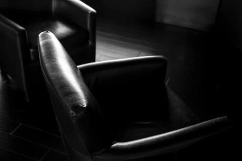 Dramatic dark lighting on comfortable office chair 库存照片