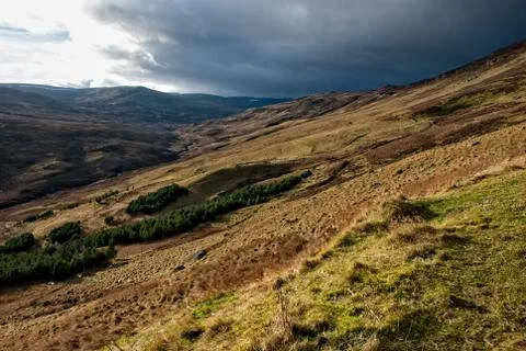 Dramatic dark sky with bright lit up landscape in the Perthshire part of the Stock Photos