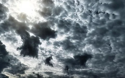 Dramatic dark storm clouds blocking the sun with light rays breaking through. Stock Photos