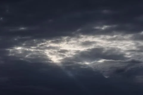 Dramatic dark storm clouds with a bright light breaking through the overcas.. 写真素材