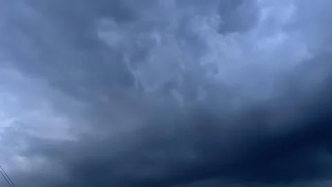 Dramatic dark storm clouds cover the sky before heavy rain and thunderstorm.. Stock Photos