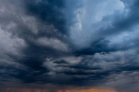 Dramatic, dark storm clouds dominate the evening sky, setting the mood. Stock Photos