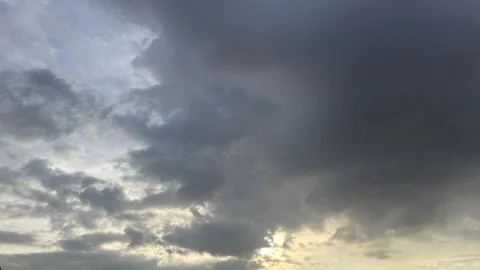 Dramatic dark storm clouds fill the sky with sun breaking through Stock Photos