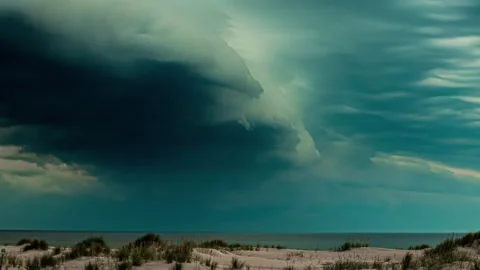 Dramatic dark storm clouds gathering over a beach and ocean - time lapse Stock Footage 279535459