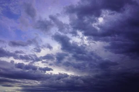 Dramatic dark storm clouds gathering across a moody purple and blue twiligh.. Stock Photos