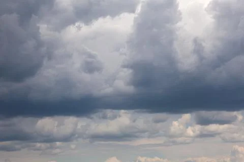 Dramatic dark storm clouds gathering in the sky with hints of light Stock Photos