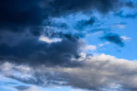 Dramatic dark storm clouds gathering in a vibrant blue sky Stock Photos