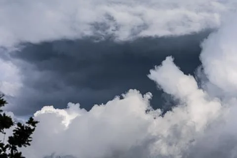 Dramatic dark storm clouds gathering in the sky above fluffy white clouds Stock Photos