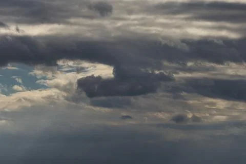 Dramatic dark storm clouds gathering in the sky before a heavy rain shower .. Stock Photos