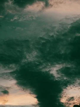 Dramatic Dark Storm Clouds with Glowing Orange Sunset Beneath, Moody Sky 写真素材