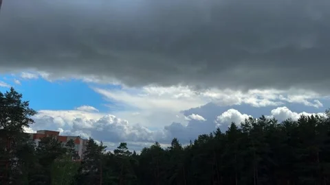 Dramatic dark storm clouds over a pine forest and residential houses Stock Footage 337553102