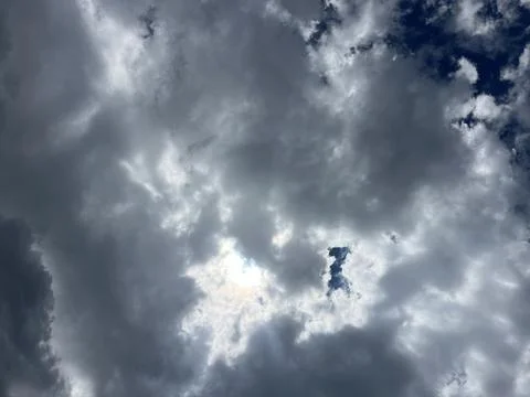 Dramatic Dark Storm Clouds with Sun Rays Breaking Through Blue Sky Stock Photos