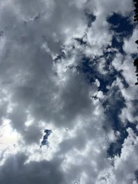 Dramatic Dark Storm Clouds with Sun Rays Breaking Through Blue Sky Stock-Fotos