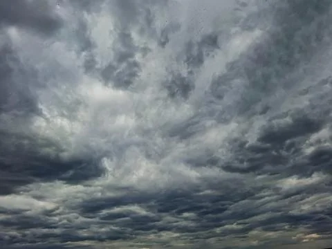 Dramatic dark stormy clouds fill the sky above a landscape, signaling upcom.. Stock Photos