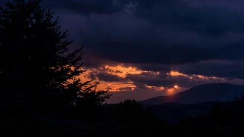 Dramatic dark sunset behind the clouds timelapse Stock Footage 111313036