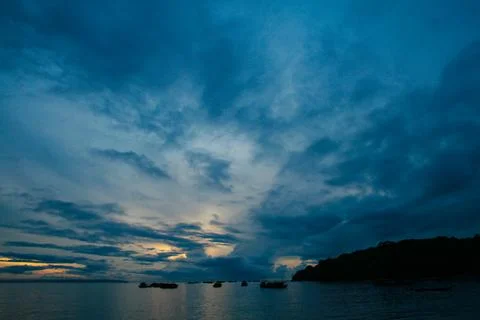 A dramatic deep blue evening sky, filled with drifting clouds Stock Photos