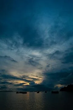 A dramatic, deep blue twilight sky, dotted with drifting clouds Stock Photos