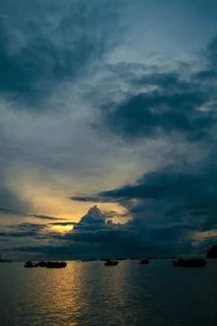 A dramatic deep blue twilight sky, dotted with drifting clouds Stock Photos