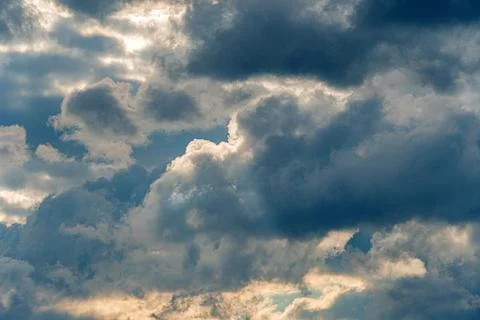Dramatic, dense gray clouds filling entire sky, dynamic lighting with sunligh 写真素材