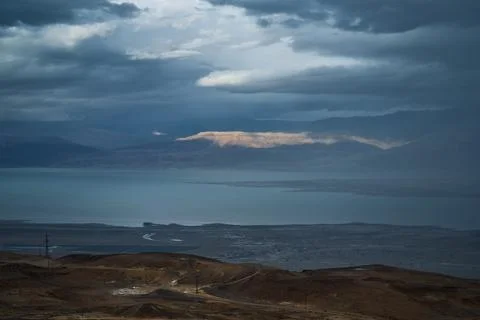 Dramatic desert coastline landscape with storm clouds over calm sea Photos