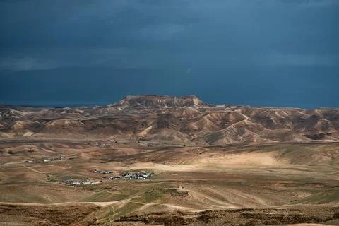 Dramatic desert coastline landscape with storm clouds over calm sea Photos
