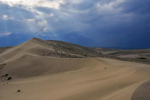 Dramatic desert dunes under sunbeams and cloudy sky Foto stock