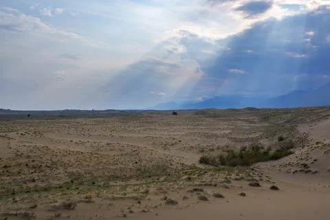 Dramatic desert dunes under sunbeams and cloudy sky Foto stock