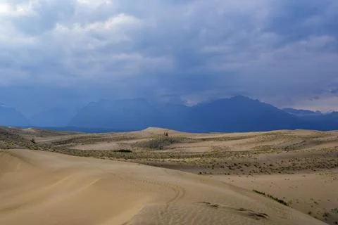 Dramatic desert dunes under sunbeams and cloudy sky Stock Photos