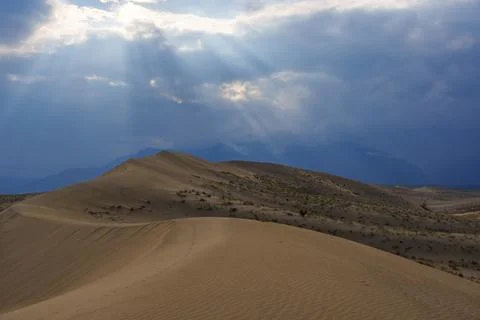 Dramatic desert dunes under sunbeams and cloudy sky Foto stock