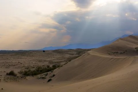 Dramatic desert dunes under sunbeams and cloudy sky Foto stock