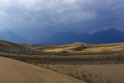 Dramatic desert dunes under sunbeams and cloudy sky Foto stock