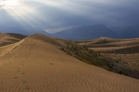 Dramatic desert dunes under sunbeams and cloudy sky Foto stock