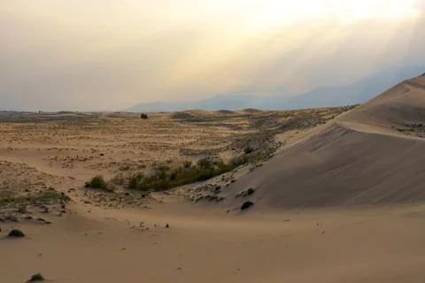 Dramatic desert dunes under sunbeams and cloudy sky Stock Photos