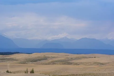 Dramatic desert dunes under sunbeams and cloudy sky Stock Photos