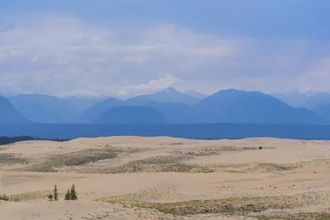 Dramatic desert dunes under sunbeams and cloudy sky Stock Photos