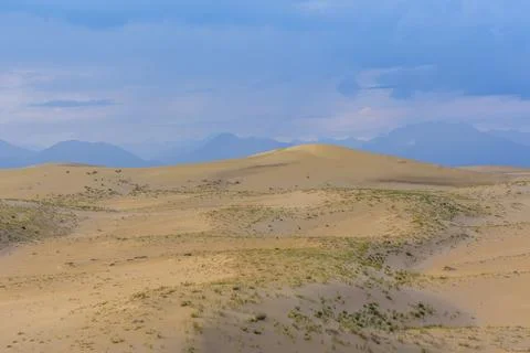 Dramatic desert dunes under sunbeams and cloudy sky Stock Photos