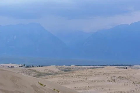 Dramatic desert dunes under sunbeams and cloudy sky Foto stock