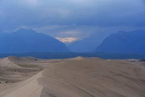 Dramatic desert dunes under sunbeams and cloudy sky Stock Photos