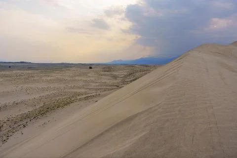 Dramatic desert dunes under sunbeams and cloudy sky Stock Photos