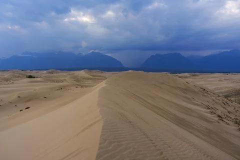 Dramatic desert dunes under sunbeams and cloudy sky Foto stock