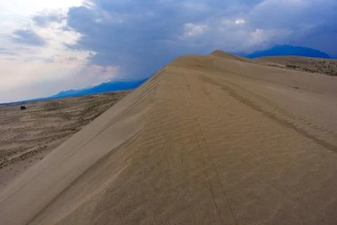 Dramatic desert dunes under sunbeams and cloudy sky Foto stock