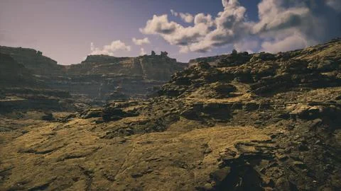 Dramatic desert landscape with rugged terrain and scattered clouds at sunset Stock Illustration