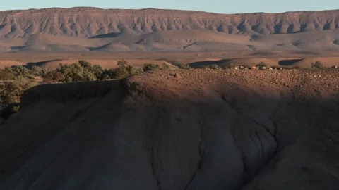 Dramatic Desert Landscape with Shadowed Mound and Eroded Plateau Stock Footage 336381195