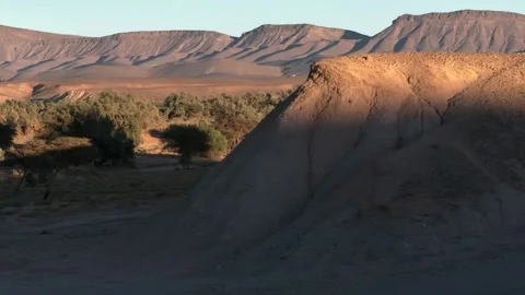Dramatic Desert Landscape with Shadowed Mound and Eroded Plateau Stock Footage 336381203