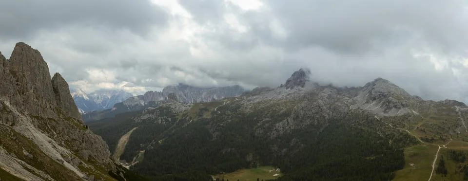 Dramatic Dolomites mountain range with forested valley and storm clouds ove.. Foto stock