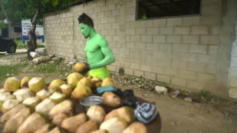Dramatic dominican man painted green on holloween holiday on caribbean coast. Stock Footage 142614573