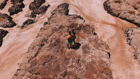 Dramatic drone footage of couple on rock at beach on Bay of Islands Vídeo Stock 107074777