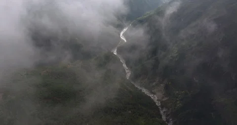 Dramatic drone view of Bhote Koshi river valley Nepal through fast moving clouds Video stock 337393965