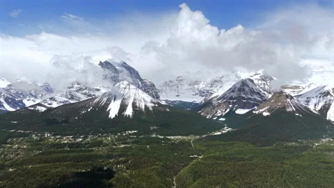 Dramatic drone view of snowy Banff peaks above forest Stock Footage 337971117